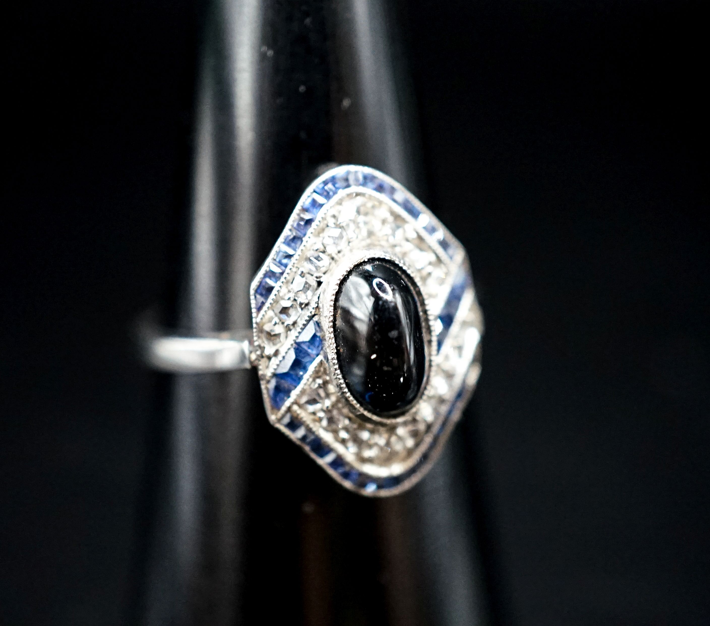 A 1920's white metal (stamped plat), sapphire and diamond ring, with central cabochon sapphire, size M, gross weight 4.6 grams.